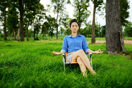 Business woman meditating and doing yoga in green field representing corporate wellness in Lewis Center, OH by FastTrack2